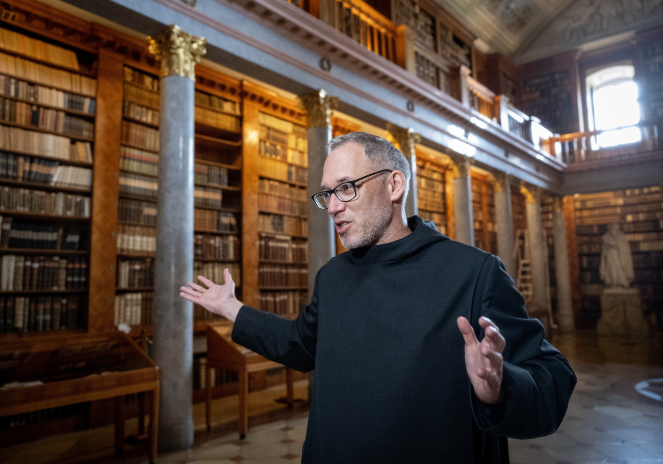 Pannonhalma, 2025. május 23.
Dejcsics Konrád OSB, a Pannonhalmi Főapátság kulturális igazgatója beszél a károkról a rovarinvázió miatt átmenetileg bezárt Pannonhalmi Főapátsági Könyvtár klasszicista teremkönyvtárában 2025. május 23-án. A fertőzést a kenyérbogár (Stegobium paniceum) elszaporodása okozta. A könyvtárat a fertőzésmentesítés idejére, június 1-jétől be kell zárni előreláthatólag 7 hónapig.
MTI/Krizsán Csaba