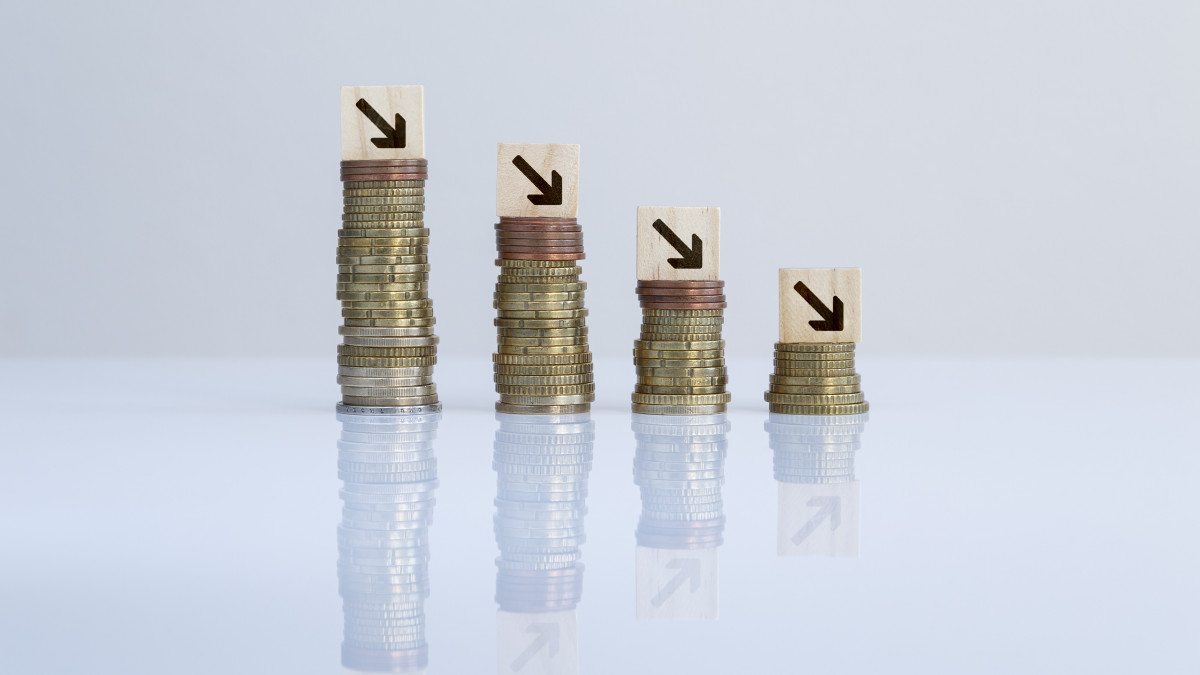 Concept photo of economic crisis, recession, financial reduction and failure.  (Note: The tiles are NOT Scrabble tiles. They are blank wooden tiles with Photoshopped generic letters. The Scrabble tiles font is different and have points at bottom right corner.)