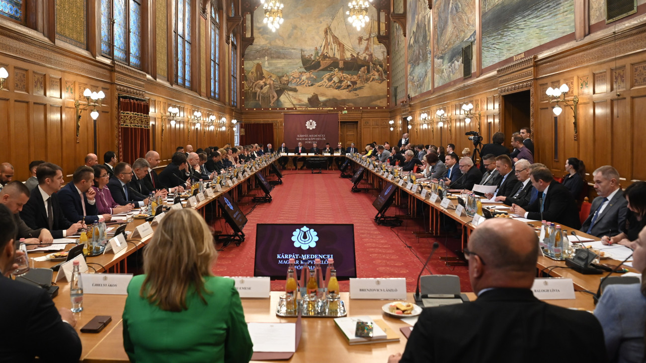 A Kárpát-medencei Magyar Képviselők Fórumának plenáris ülése az Országház Vadásztermében 2025. június 5-én. Szemben középen Orbán Viktor miniszterelnök (b3) és Kövér László, az Országgyűlés elnöke (b4), balról Pánczél Károly, az Országgyűlés nemzeti összetartozás bizottságának fideszes elnöke (b) és Nacsa Lőrinc, a Miniszterelnökség nemzetpolitikáért felelős államtitkára (b2), jobbról Veress László, a házelnök kabinetfőnöke (b5), Kovács Krisztián, az Országgyűlés Hivatalának külügyi igazgatója (b6) és Sárdi Péter, az Országgyűlés elnökének külügyi főtanácsadója, az Országgyűlés Hivatalának nyugalmazott külügyi igazgatója (j).
